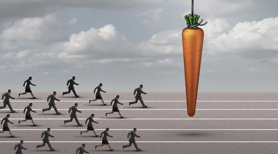 Employee incentive business concept as a group of businessmen and businesswomen running on a track towards a dangling carrot on a moving cable as a financial reward metaphor to motivate for a goal.