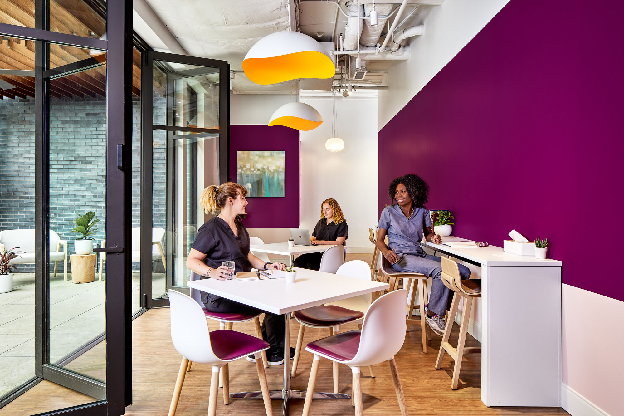 staff break room by alda ly architecture features purple walls and bifold doors that open to a patio