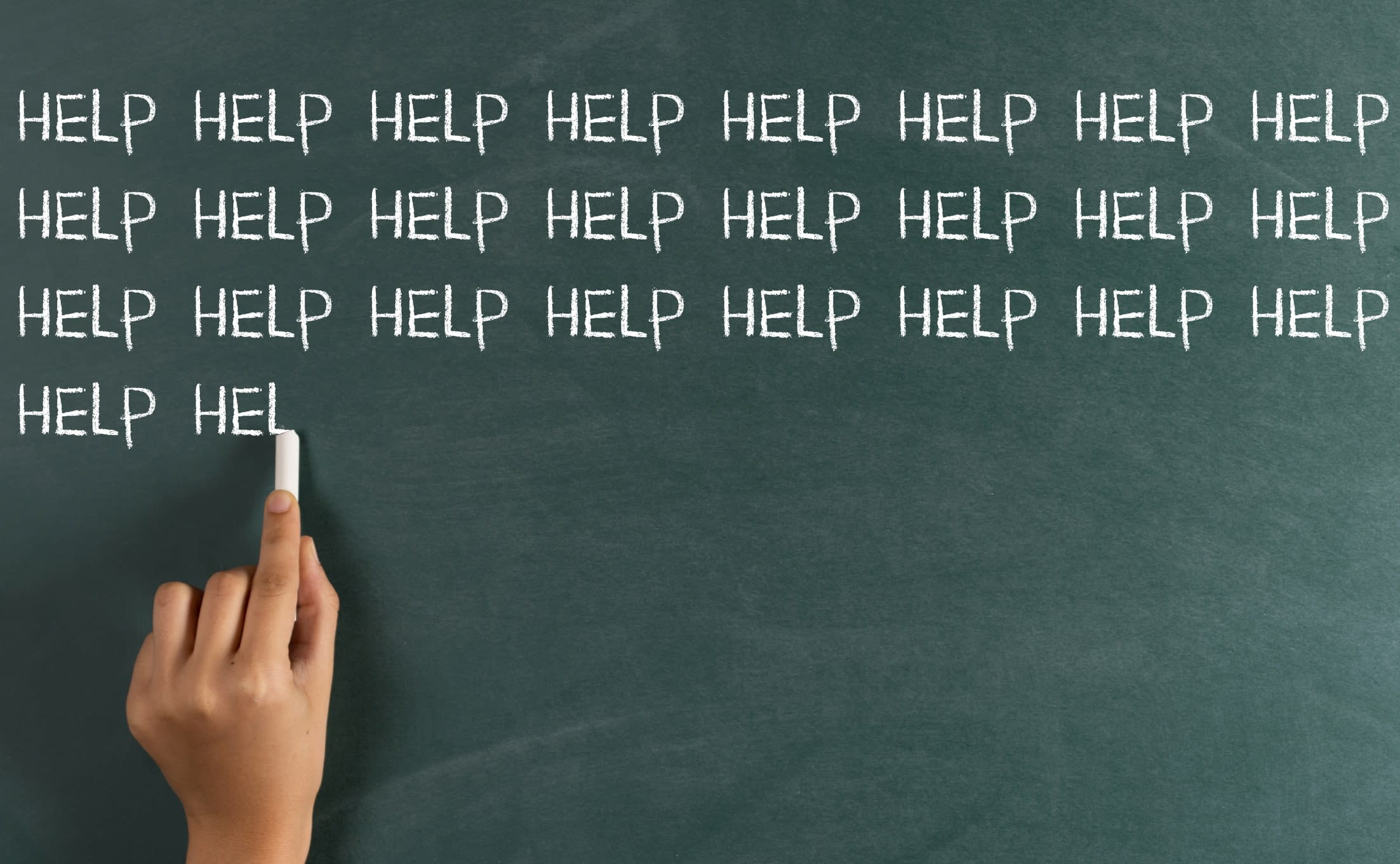 The word 'HELP' being repeatedly written in chalk on a blackboard