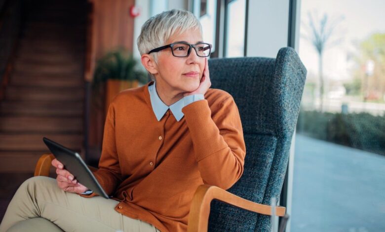 senior woman with tablet looking out widnow x.jpeg