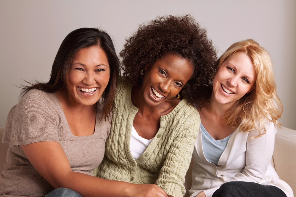 three young women laughing and smiling together