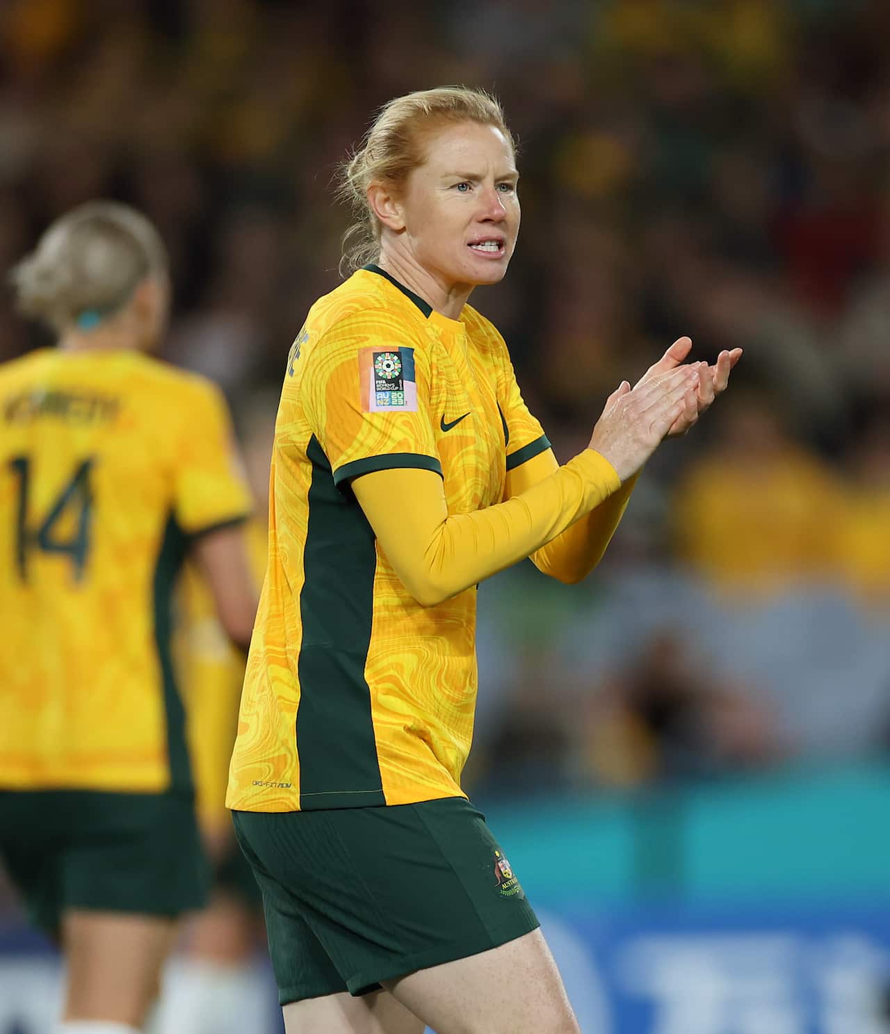 A woman in a long sleeve yellow football shirt