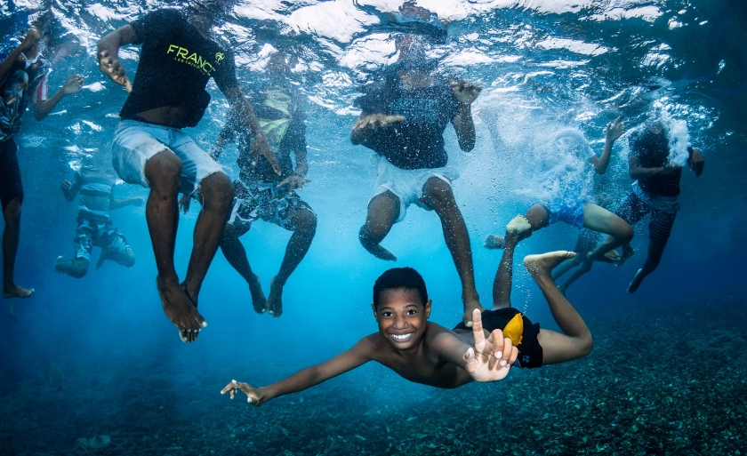 Children swim in the ocean 	