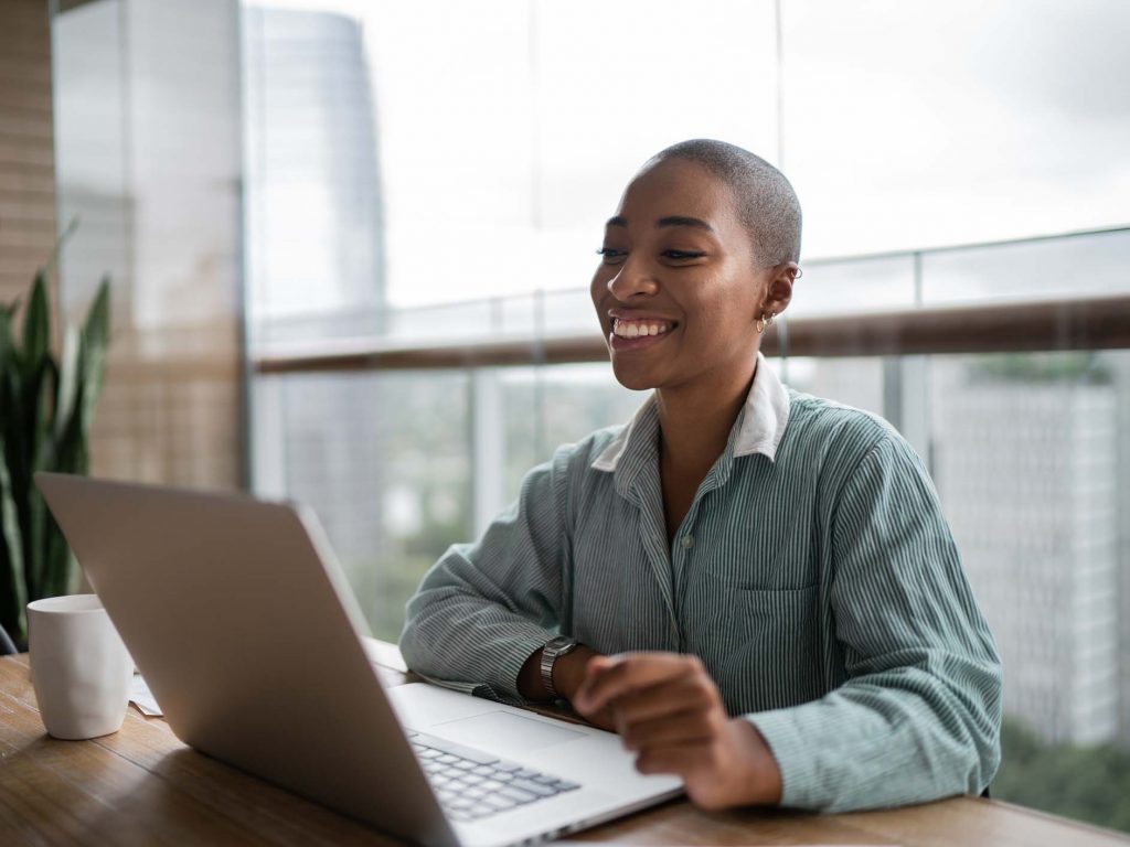Young woman working and doing a virtual business meeting on laptop at home.